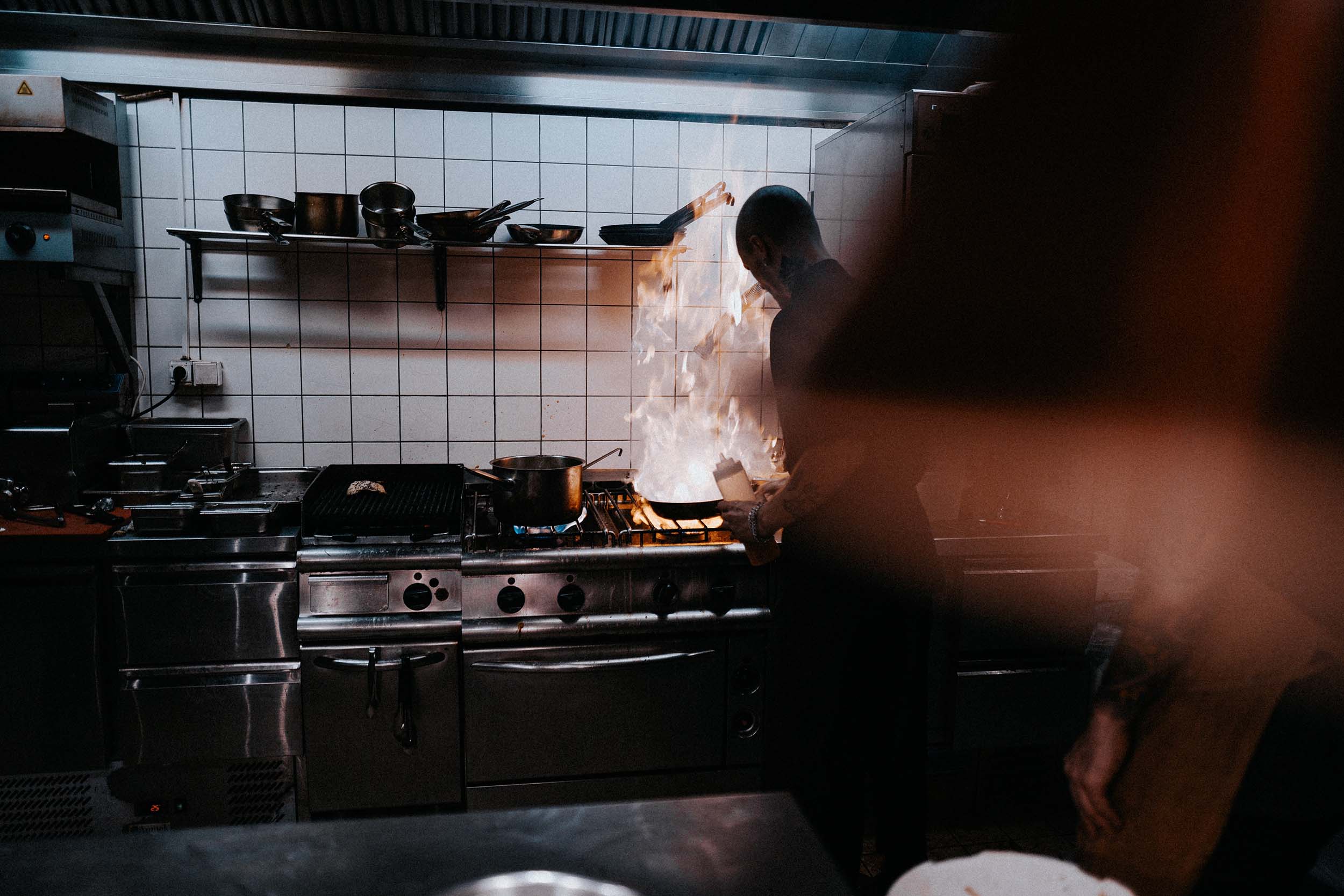 A man cooking on a gas stove in a restaurant